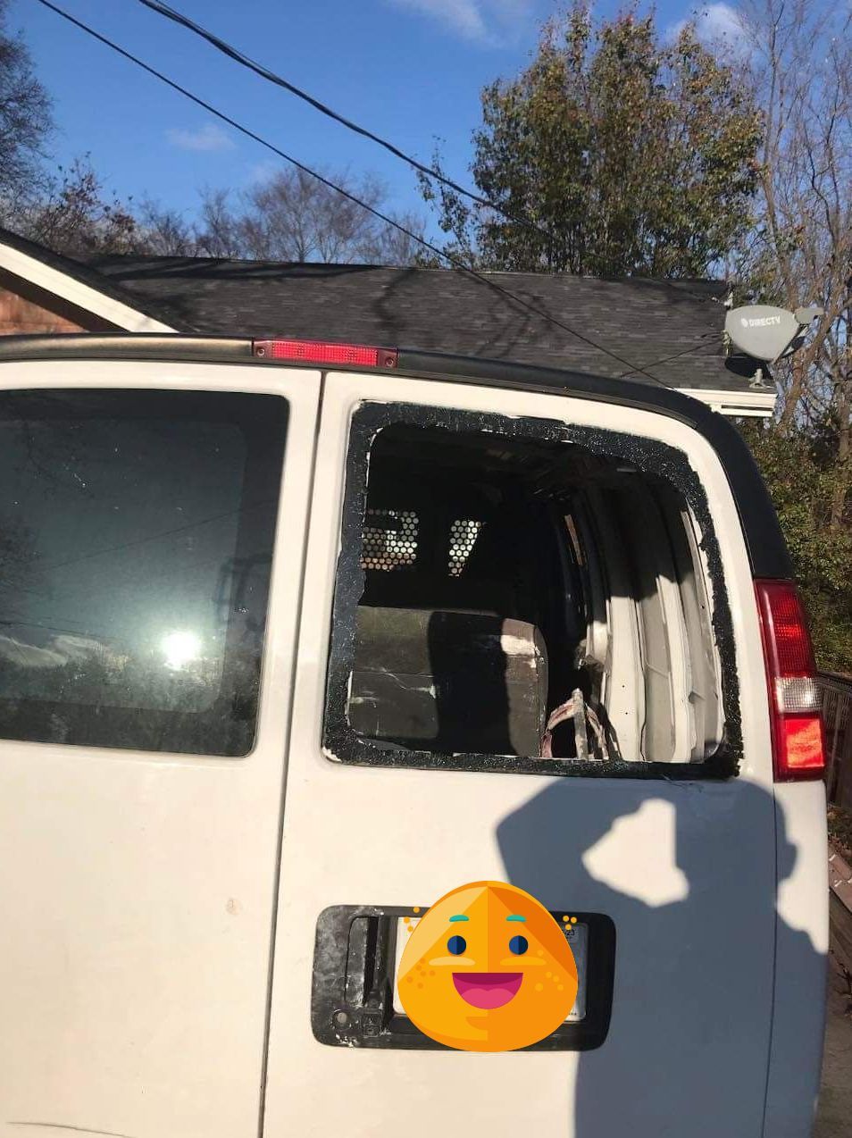 White SUV with a shattered rear side window, parked outdoors under a blue sky.