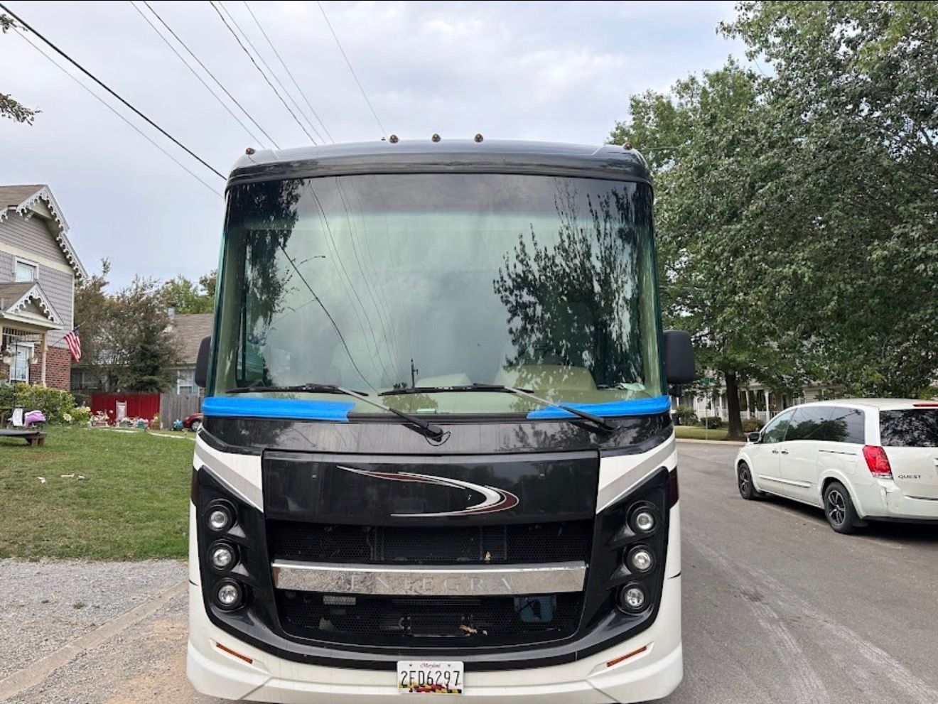 Front view of a white and black bus parked on a residential street